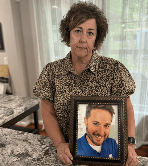 Grieving Mom with photo of the son she lost